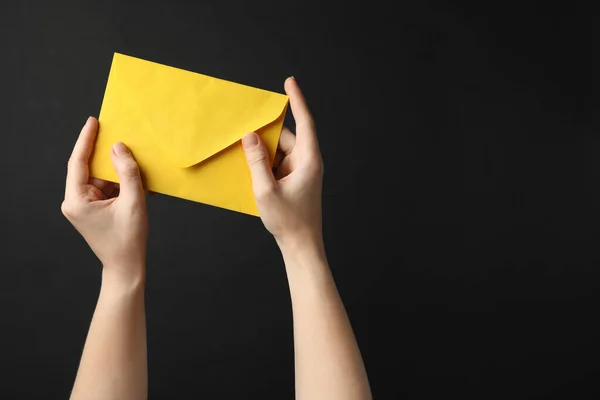 Mulher Segurando Envelope Papel Amarelo Fundo Preto Close — Fotografia de Stock