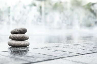 Islak şehir caddesinde spa taşları yığını, metin için boşluk