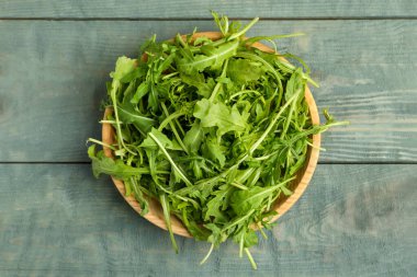 Mavi ahşap masada taze roka, üst manzara.