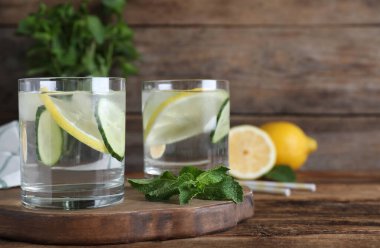 Ahşap masada salatalık, limon ve nane ile taze su. Metin için boşluk