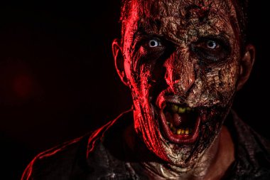 Karanlık arka planda korkunç bir zombi, yakın plan. Cadılar Bayramı canavarı