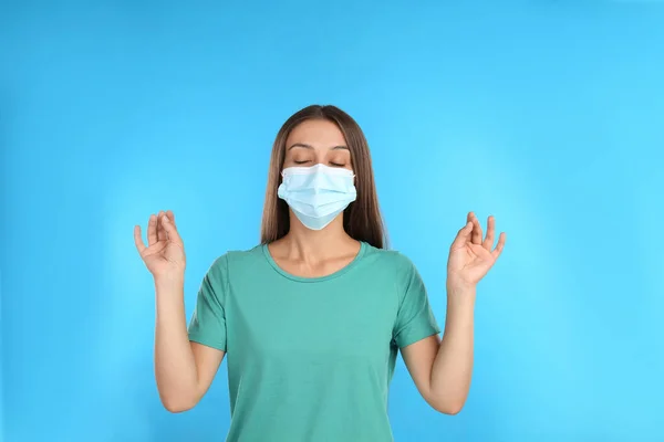 Woman Protective Mask Meditating Light Blue Background Dealing Stress Caused — Stock Photo, Image