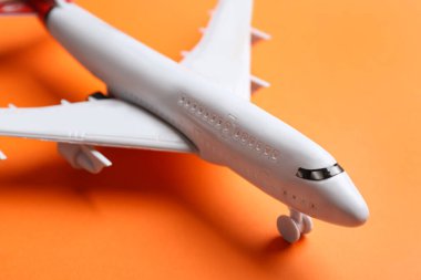 Turuncu arkaplanda oyuncak uçak, yakın çekim görüntüsü