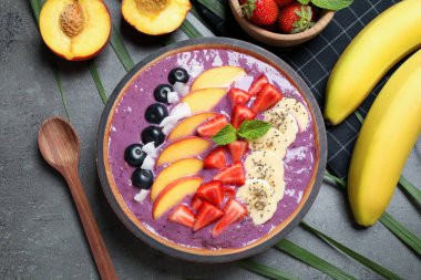 Gri masada servis edilen meyveli leziz acai smoothie.