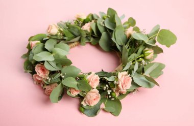 Pembe arka planda güzel çiçeklerden yapılmış çelenk