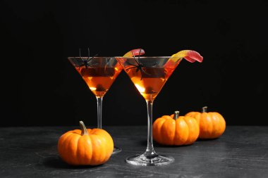 Gri masadaki içkilerle süslenmiş bardaklar. Cadılar Bayramı