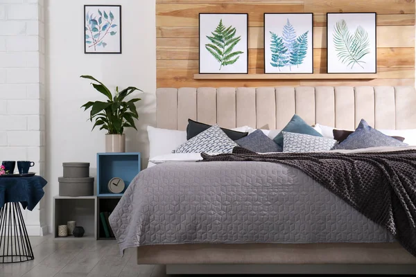 大きな快適なベッドと美しい絵画とスタイリッシュな部屋のインテリア — ストック写真