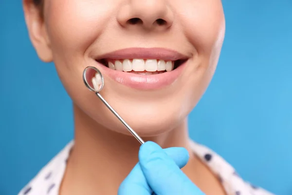 Läkare Undersöker Kvinnans Tänder Blå Bakgrund Närbild Kosmetisk Tandvård — Stockfoto