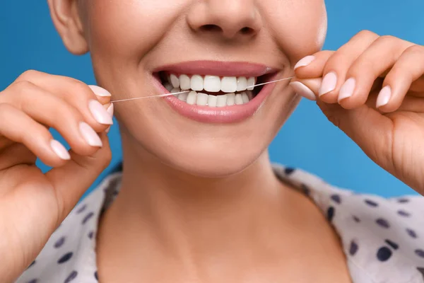Młoda Kobieta Nici Dentystycznej Niebieskim Tle Zbliżenie Stomatologia Kosmetyczna — Zdjęcie stockowe