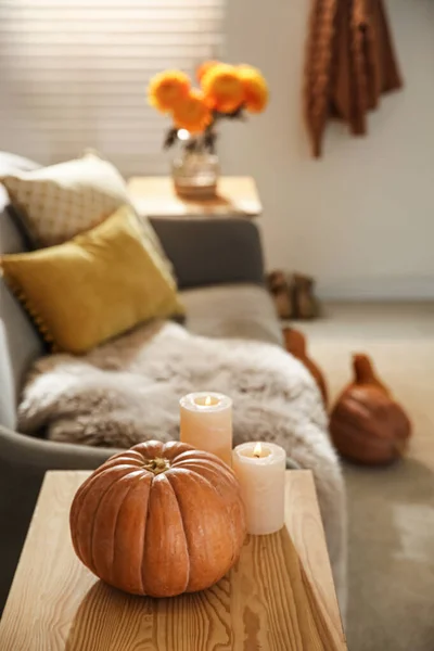 部屋の木製のテーブルの上にカボチャと燃えるろうそく 秋の色にインスパイアされた居心地の良いインテリア — ストック写真