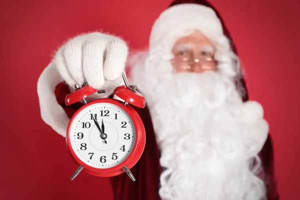 Papai Noel Segurando Despertador Fundo Vermelho Foco Mão Contagem Regressiva — Fotografia de Stock