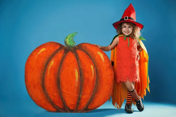 Cute Little Girl Dekoracyjne Dyni Noszenie Kostiumu Halloween Jasnoniebieskim Tle — Zdjęcie stockowe