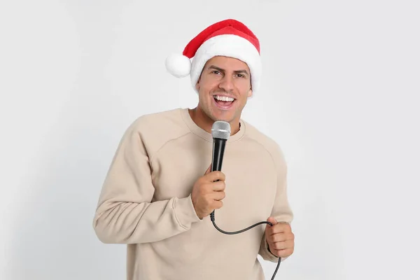Щасливий Чоловік Капелюсі Санта Клауса Співає Мікрофоном Білому Тлі Різдвяна — стокове фото