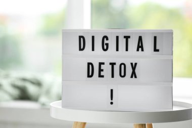 Beyaz masa üzerinde dijital detoks ifadesiyle aydınlatma kutusu