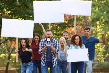 Dışarıda megafonlu duygusal bir genç adam protesto yapıyor.