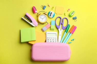 Düz kompozisyon ve sarı arka planda okul kağıtları. Okula geri dön.