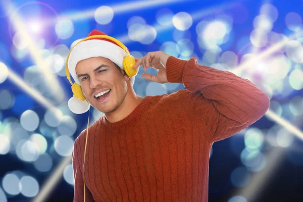 Щасливий Чоловік Санта Капелюсі Слухає Різдвяну Музику Навушниками Яскравому Фоні — стокове фото
