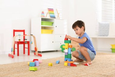Evdeki renkli bloklarla oynayan sevimli küçük çocuk. Eğitim oyuncağı