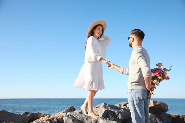 Unge Man Ger Blommor Till Sin Fru Stranden Bröllopsresa — Stockfoto