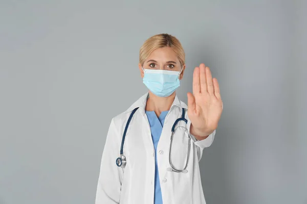 Dokter Beschermend Masker Toont Stop Gebaar Grijze Achtergrond Voorkomen Van — Stockfoto