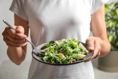 Arka planda armut salatası olan bir kadın, yakın plan.