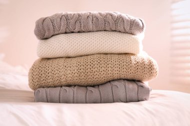 İçerideki yatakta katlanmış kalın kazaklar.