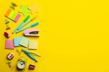 Sarı arka planda okul kırtasiyesi, metin için yeri olan düz bir yer. Okula geri dön.