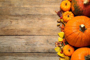 Düz kompozisyon, balkabakları ve sonbahar yaprakları ahşap masanın üzerinde yatıyordu. Metin için boşluk