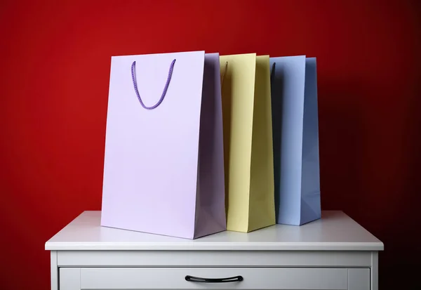 Bolsas Compras Papel Cómoda Blanca Sobre Fondo Rojo —  Fotos de Stock