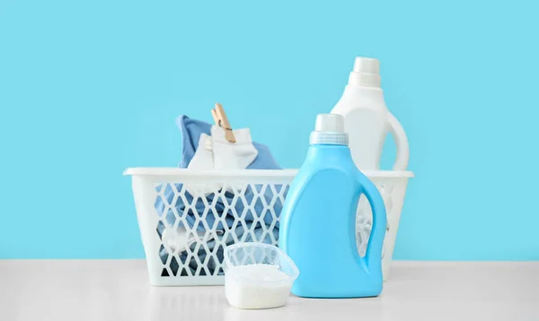 Detergenti Vestiti Bambini Sul Tavolo Bianco Vicino Alla Parete Azzurra — Foto Stock
