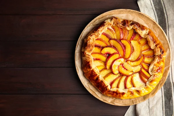 Delicious fresh peach pie on wooden table, top view. Space for text