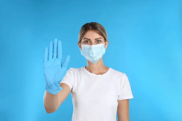 Mujer Con Máscara Protectora Mostrando Gesto Stop Sobre Fondo Azul — Foto de Stock