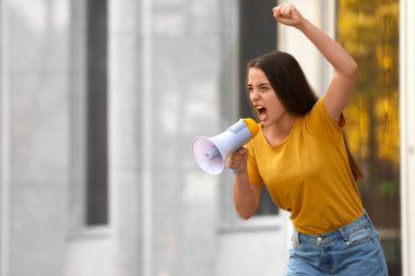 Açık havada megafonlu duygusal genç bir kadın. Protesto lideri
