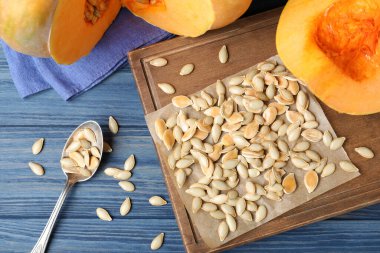 Mavi ahşap masa üzerinde balkabağı tohumları yığını ile düz kompozisyon yatıyordu