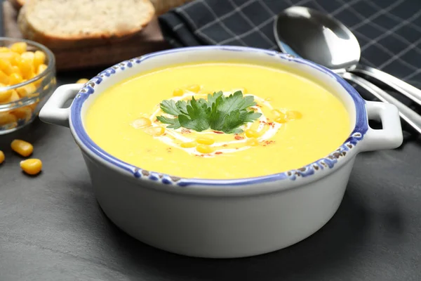 Delicious creamy corn soup served on black table