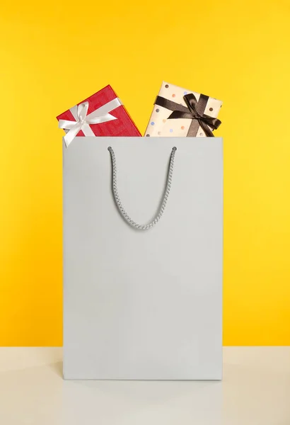 Бумажный Пакет Полный Подарочных Коробок Желтом Фоне — стоковое фото