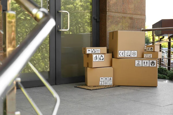 Kartonnen Dozen Met Verschillende Verpakkingssymbolen Deurmat Bij Ingang Pakketbezorging — Stockfoto