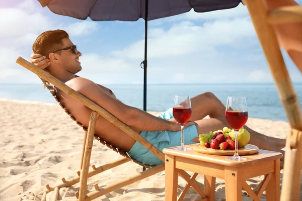 幸せな男はリゾートで日当たりの良いビーチで休んで — ストック写真
