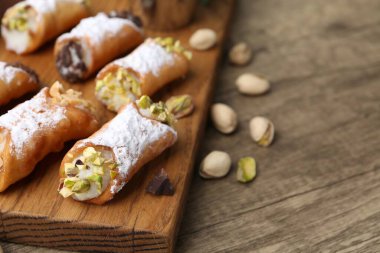 Ricotta peynirli, fıstıklı, fıstıklı, çikolatalı ve pudra şekerli nefis cannoli, yakın plan. Metin için boşluk