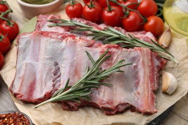 Taze et kaburgaları, domatesler ve baharatlar ahşap masada, yakın plan.