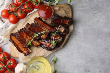 Kızarmış biftek pirzolası, mikroyeşillikler, domatesler ve gri dokuma masasında diğer ürünler, düz yatak. Metin için boşluk