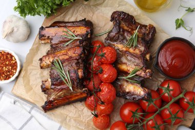Biberiyeli biftek kaburgaları, domatesler ve diğer ürünler masada.