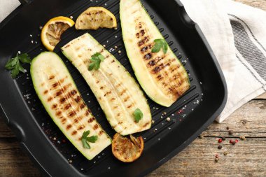 Ahşap masada baharatlı ve limonlu leziz ızgara kabak dilimleri.