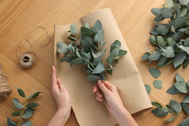 Çiçekçi okaliptüs dallarından güzel bir buket yapıyor.