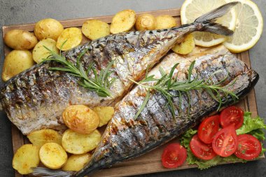 Gri masadaki baharatlı ve sebzeli kızarmış uskumrular. Ev yapımı deniz ürünleri yemeği.