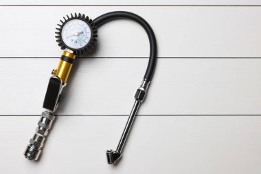 Açık gri ahşap masa üzerinde göstergesi olan bir enflasyon tabancası.