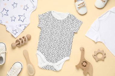 Bej arka planda şık bebek kıyafetleri ve aksesuarları, düz yatış