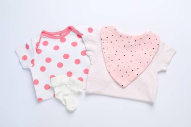 Beyaz arka planda şık bebek kıyafetleri ve aksesuarları, düz yatış