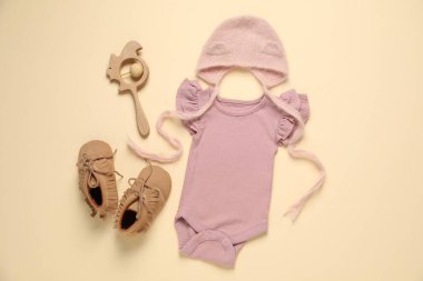 Bej arka planda şık bebek kıyafetleri ve aksesuarları, düz yatış