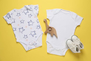 Şık bebek tulumları ve sarı arka planda aksesuarlar.